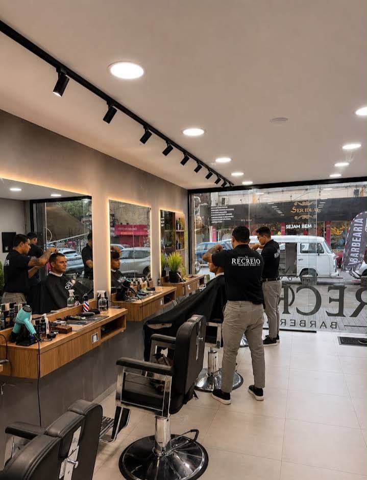 Barbeiros atendendo clientes no salão da Recreio Barber Shop